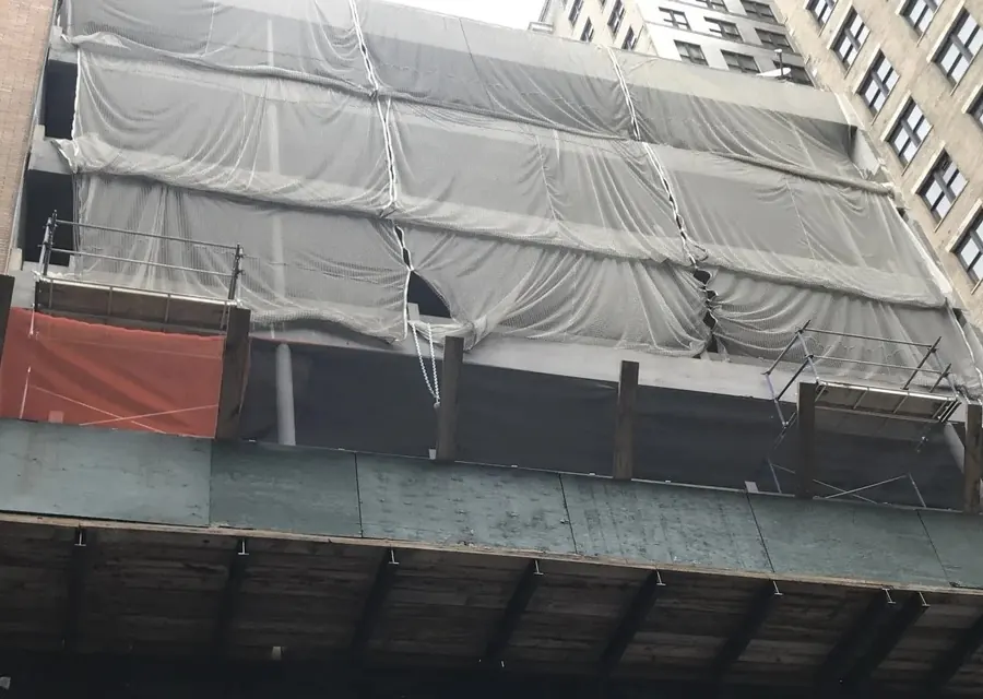 Building facade wrapped in protective sheeting during restoration